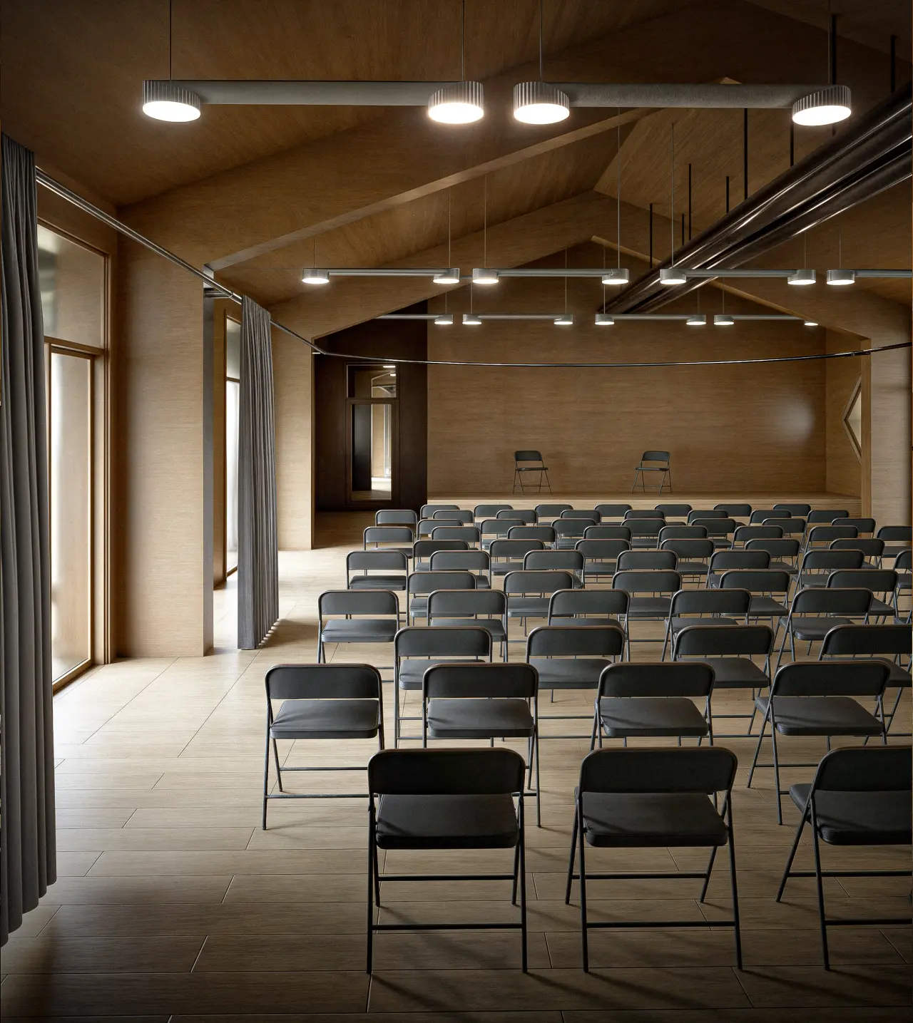 Interiorul sălii de conferințe, cu rânduri de scaune pliante orientate spre podium și tavan din lemn în două ape